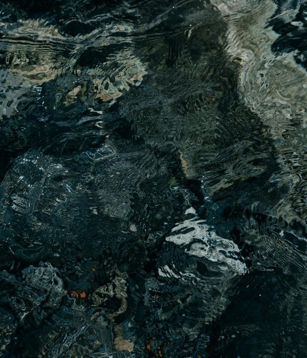 A person in a fluid motion pose against a minimalist dark background.